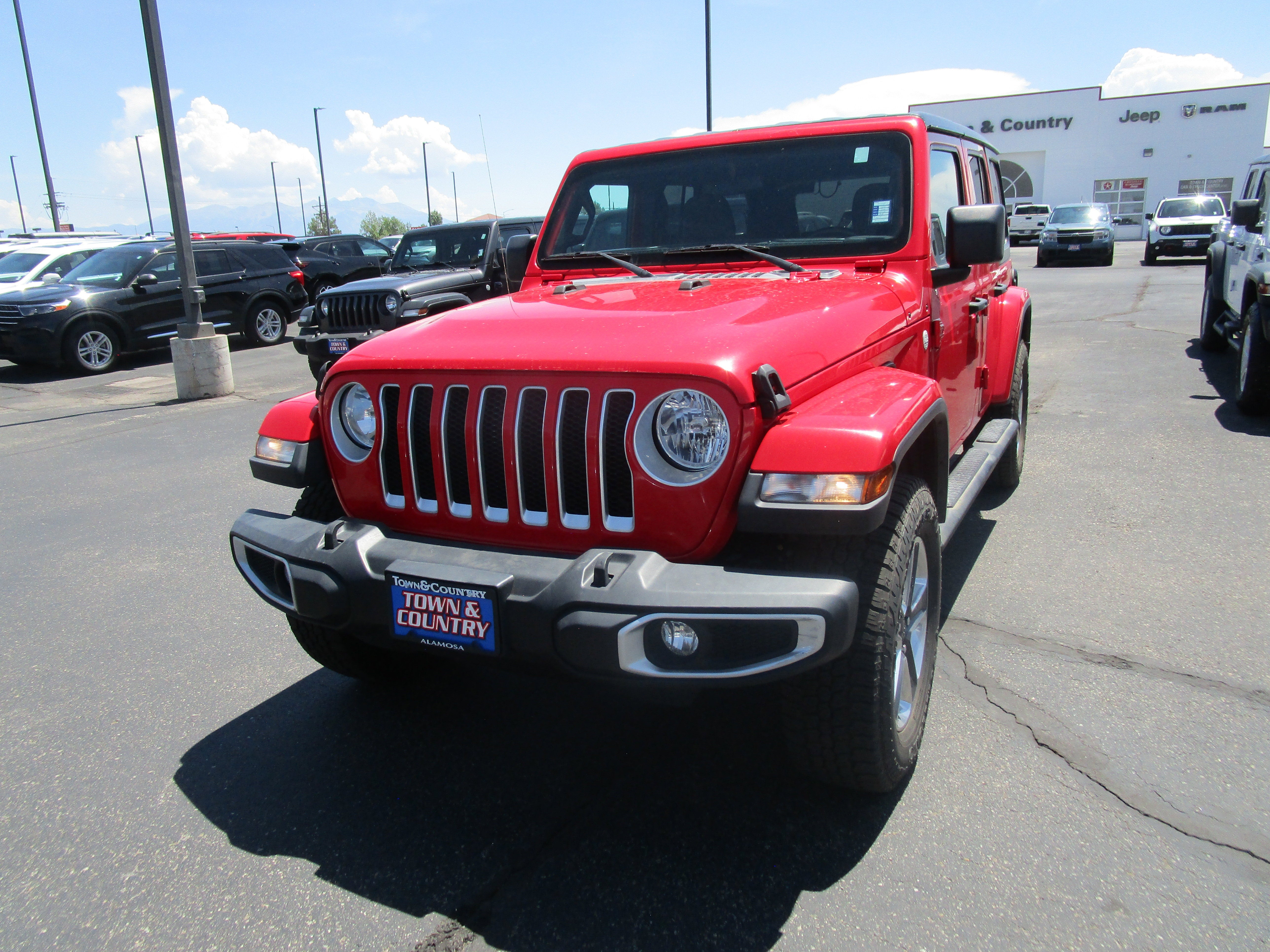 2021 Jeep Wrangler Unlimited Sahara in Red — front three-quarter view