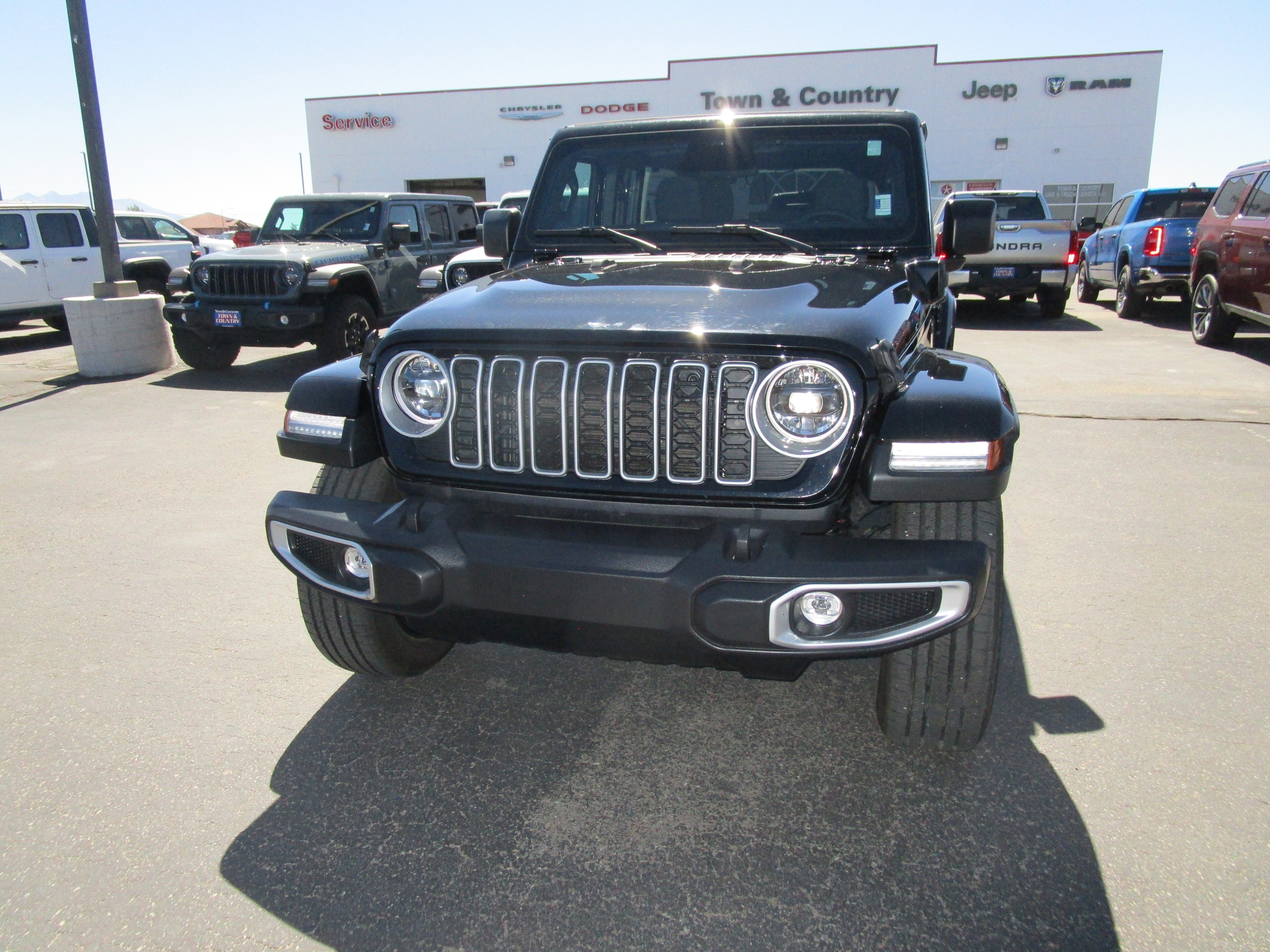 2025 Jeep Wrangler 4xe Sahara in Black — front three-quarter view