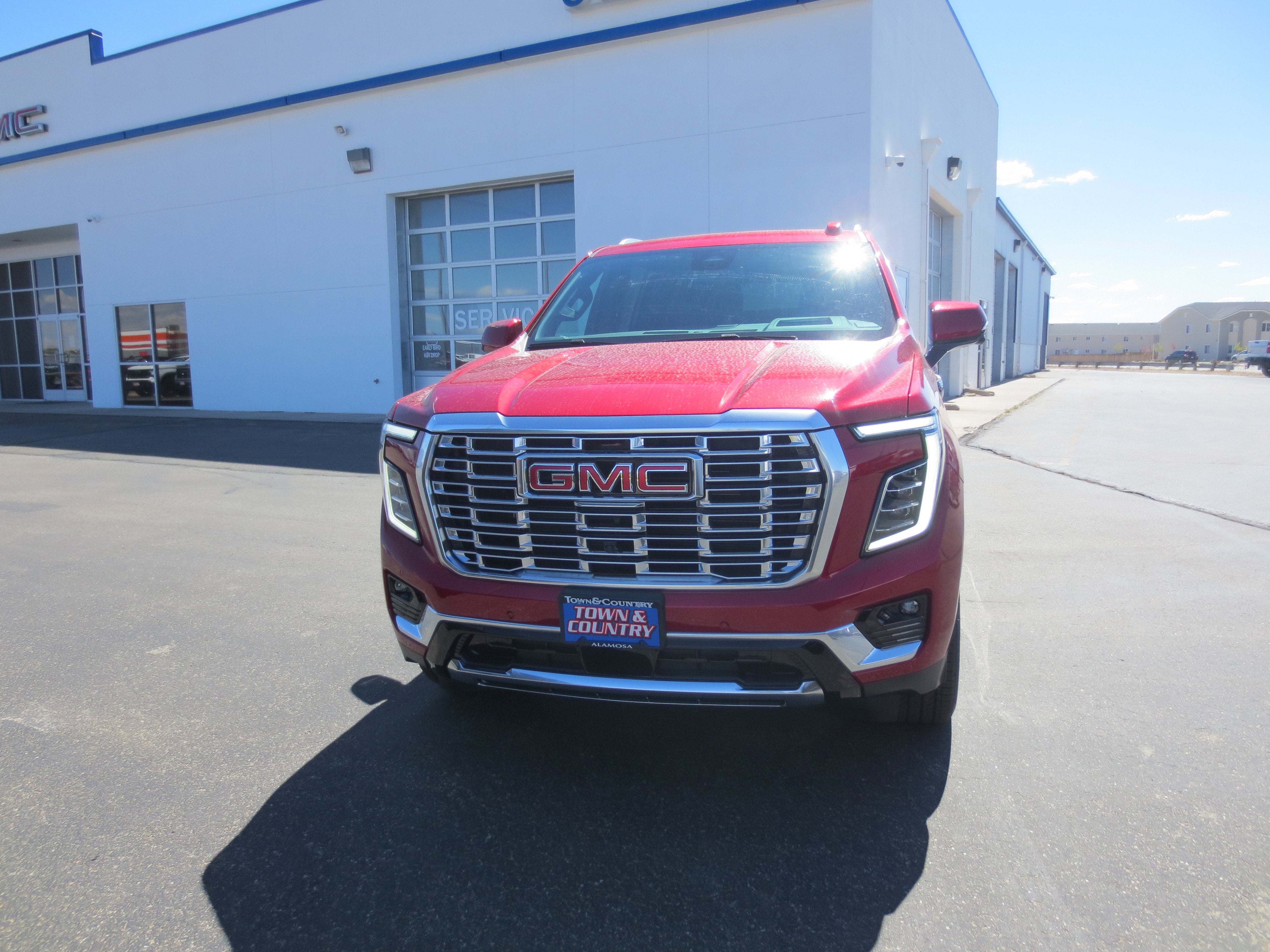 2026 GMC Yukon XL Denali in Volcanic Red Tintcoat — front three-quarter view